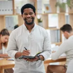 african-business-man-writing-in-book-taking-notes-2022-12-07-21-38-45-utc